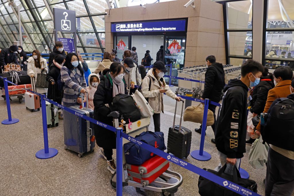 SHANGHAI, CHINA - JANUARY 08: Passengers line up to enter T2 terminal at Shanghai Pudong International Airport on January 8, 2023 in Shanghai, China. Mandatory quarantine requirements and on-arrival polymerase chain reaction (PCR) tests are not required for inbound travelers in Shanghai as China further optimizes the international exchanges. (Photo by Yin Liqin/China News Service/VCG via Getty Images)