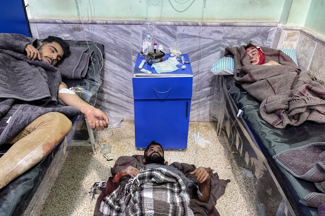 Dois homens feridos e uma criança recebem tratamento no hospital Bab al-Hawa após um terremoto -