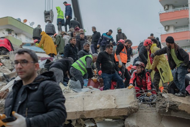 Equipes de resgate procuram sobreviventes nos escombros de prédios desabados em Adana, na Síria -
