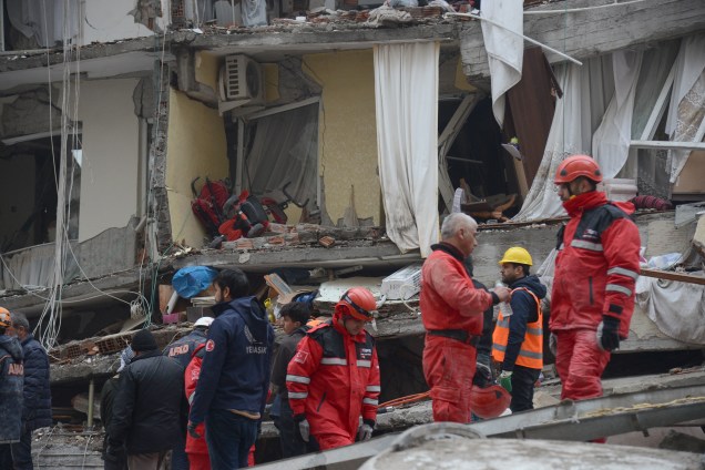 Equipes de resgate e voluntários conduzem operações de busca e resgate nos escombros de um prédio desabado, em Diyarbakir, na Síria -