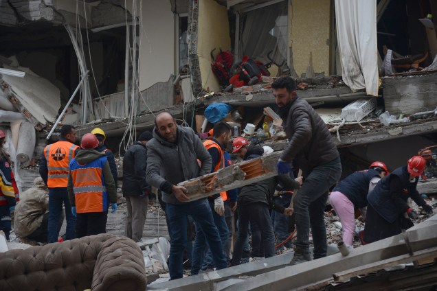 Equipes de resgate e voluntários conduzem operações de busca e resgate nos escombros de um prédio desabado, em Diyarbakir, na Síria -