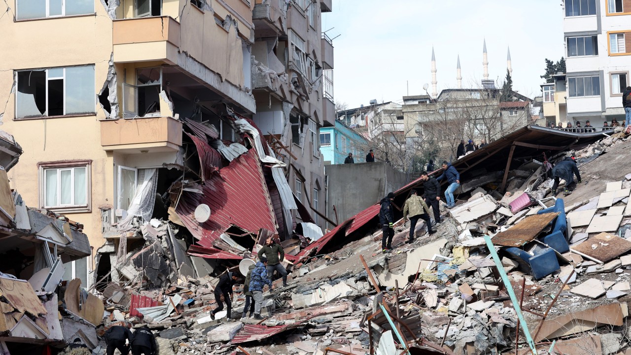 Civilians look for survivors under the rubble of collapsed buildings in Kahramanmaras, close to the quake's epicentre, the day after a 7.8-magnitude earthquake struck the country's southeast, on February 7, 2023. - Rescuers in Turkey and Syria braved frigid weather, aftershocks and collapsing buildings, as they dug for survivors buried by an earthquake that killed more than 5,000 people. Some of the heaviest devastation occurred near the quake's epicentre between Kahramanmaras and Gaziantep, a city of two million where entire blocks now lie in ruins under gathering snow. (Photo by Adem ALTAN / AFP)