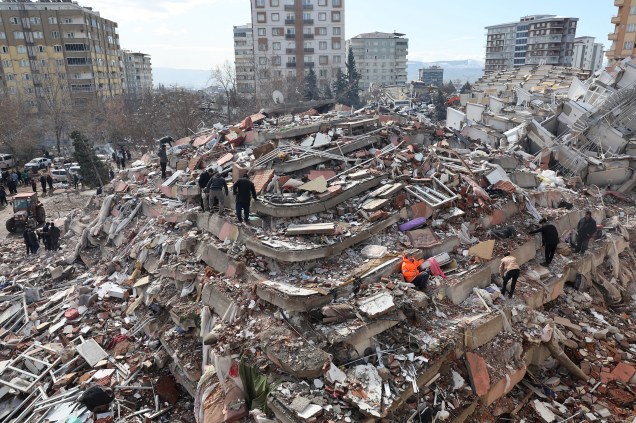 Civis procuram sobreviventes sob os escombros de prédios desabados em Kahramanmaras, perto do epicentro do terremoto -