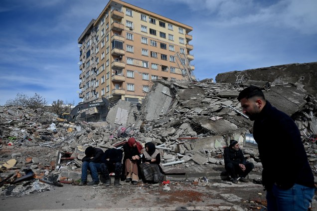 Famílias esperam entre os escombros de edifícios em Kahramanmaras, o epicentro do terremoto -