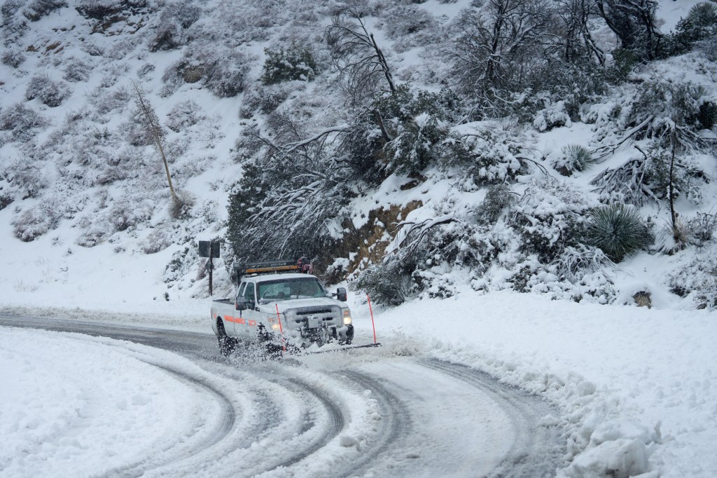 A plow clears the road for travel on the Angeles Crest Highway during a blizzard in the San Gabriel Mountains in the Angeles National Forest, California, on February 24, 2023. - Californians more used to flip flops and shorts were wrapping up warm Thursday as a rare winter blizzard, the first in more than 30 years, loomed over Los Angeles, even as the US East Coast basked in summer-like temperatures. (Photo by Allison Dinner / AFP)