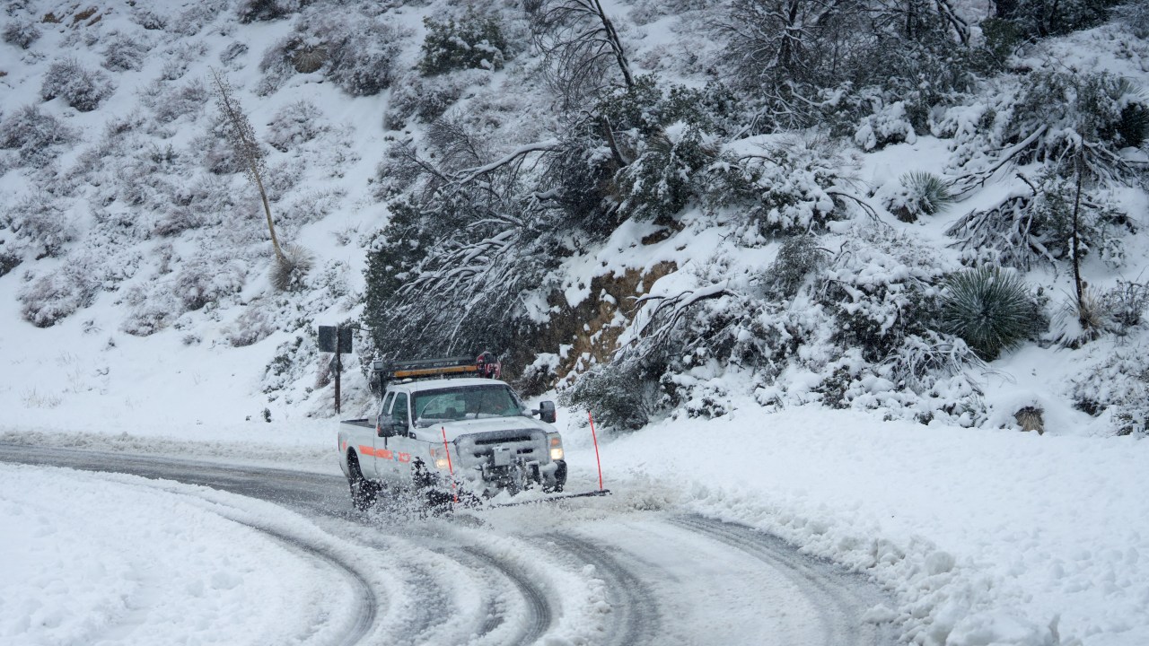 A plow clears the road for travel on the Angeles Crest Highway during a blizzard in the San Gabriel Mountains in the Angeles National Forest, California, on February 24, 2023. - Californians more used to flip flops and shorts were wrapping up warm Thursday as a rare winter blizzard, the first in more than 30 years, loomed over Los Angeles, even as the US East Coast basked in summer-like temperatures. (Photo by Allison Dinner / AFP)