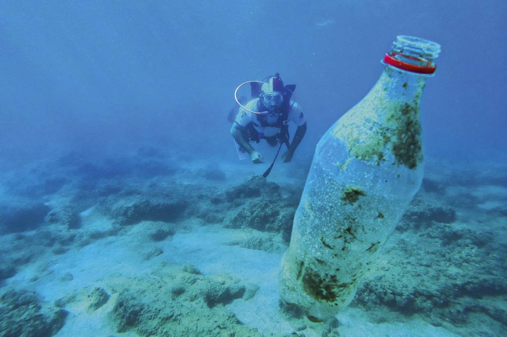 POLUIÇÃO - Voluntário recolhe plástico no mar da Turquia: o descarte inadequado amplia os efeitos do aquecimento global -