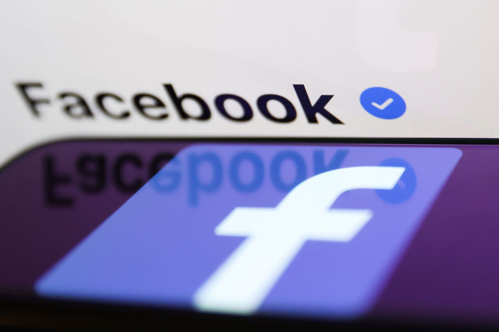 Uma marca de verificação azul na página do Facebook no Facebook exibida na tela de um laptop e o logotipo do Facebook exibido na tela do telefone são vistos nesta foto ilustrativa tirada na Polônia em 19 de fevereiro de 2023. (Foto de Jakub Porzycki/NurPhoto via Getty Images)