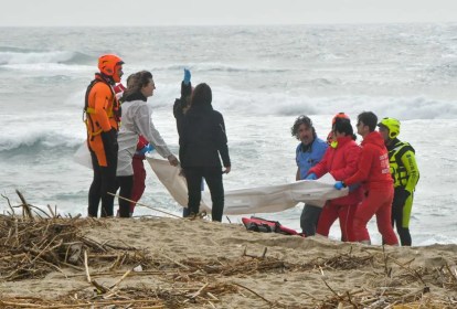 Equipes de resgate retiram corpo de vítima depois que um barco de migrantes naufragou em mar na Calábria