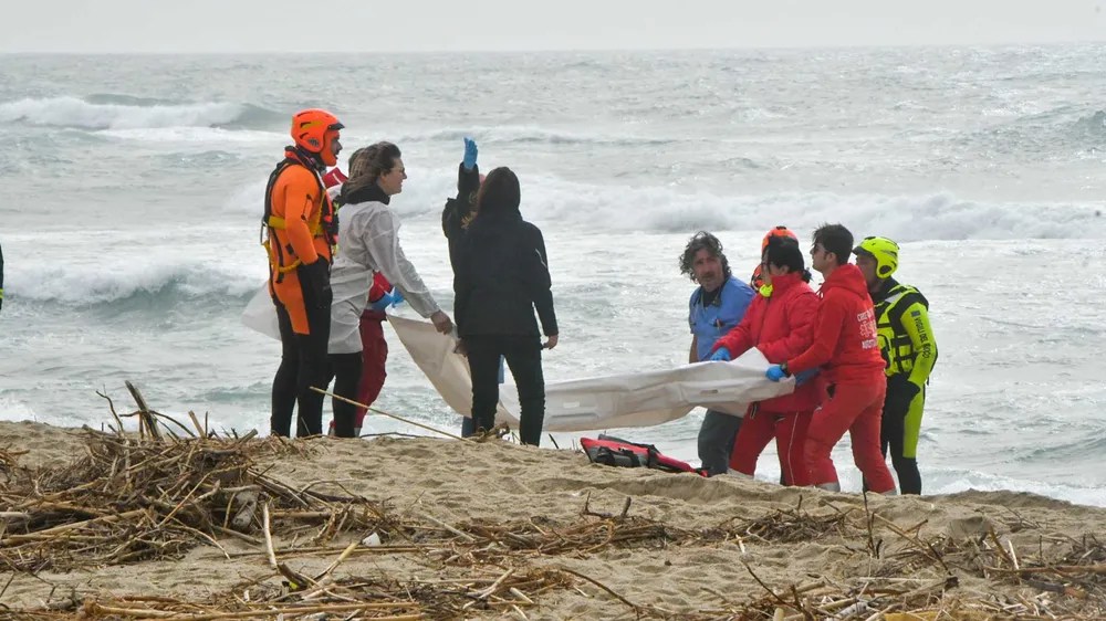 Equipes de resgate retiram corpo de vítima depois que um barco de migrantes naufragou em mar na Calábria