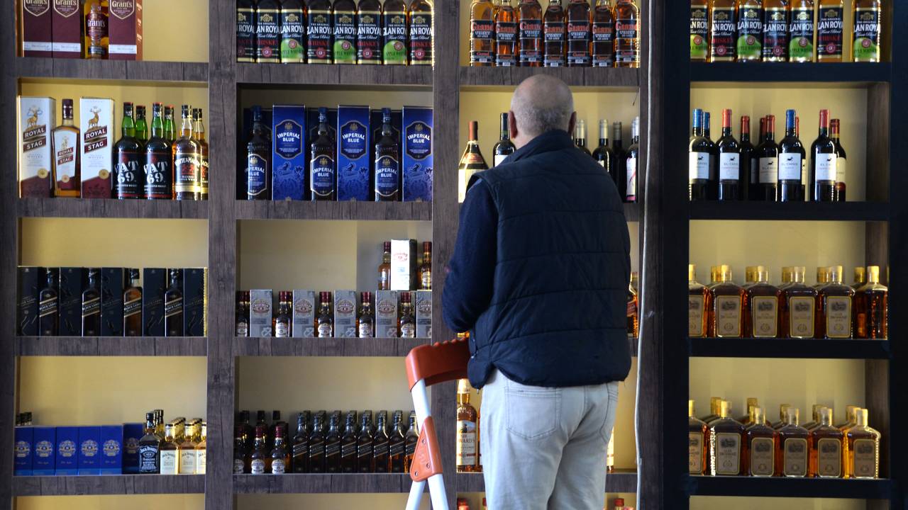 A shopworker arranges whisky bottles on a shelf at a liquor shop in Mosul on February 23, 2023. - Iraq's customs authorities announced on March 4, 2023, the official ban on the import, sale and manufacture of alcoholic beverages. (Photo by Zaid AL-OBEIDI / AFP)