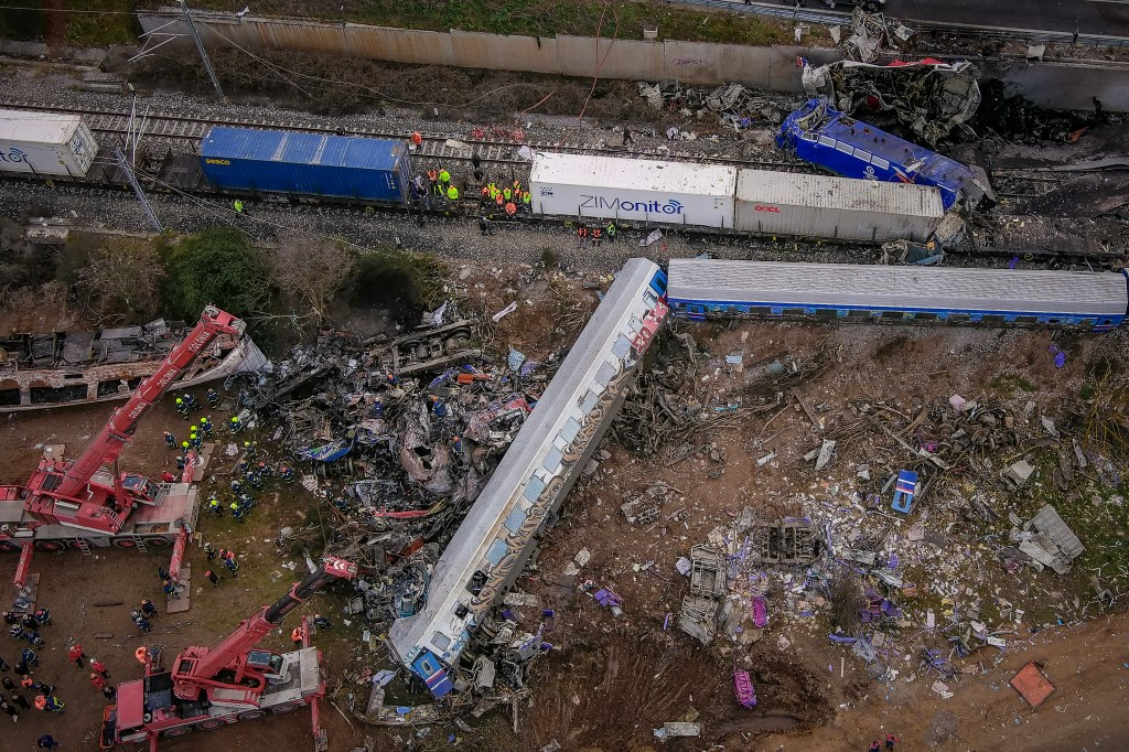 This aerial drone photograph taken on March 1, 2023, shows emergency crews searching wreckage after a train accident in the Tempi Valley near Larissa, Greece. - At least 32 people were killed and another 85 injured after a collision between two trains caused a derailment near the Greek city of Larissa late at night on February 28, 2023, authorities said. A fire services spokesman confirmed that three carriages skipped the tracks just before midnight after the trains -- one for freight and the other carrying 350 passengers - collided about halfway along the route between Athens and Thessaloniki. (Photo by Vasilis VERVERIDIS / Eurokinissi/motionteam / AFP)