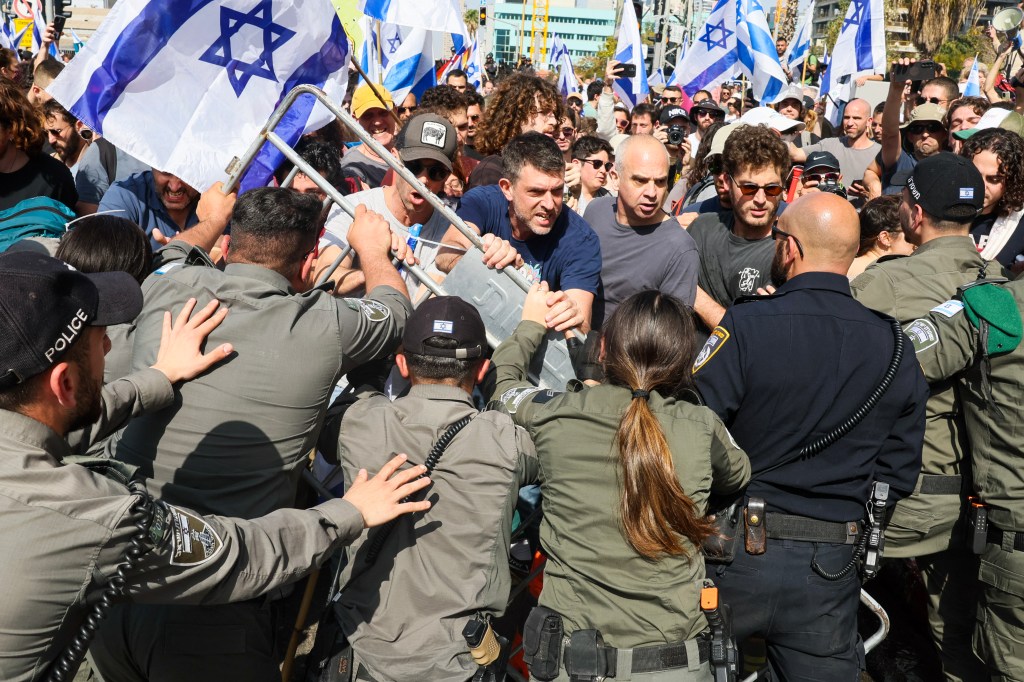 Protesters scuffle with members of Israeli security forces during a demonstration against the government's controversial justice reform bill in Tel Aviv on March 1, 2023. (Photo by JACK GUEZ / AFP)