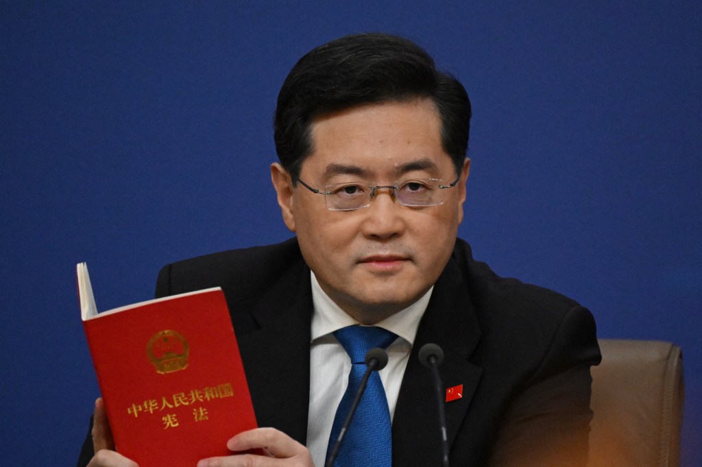 China's Foreign Minister Qin Gang holds a copy of China's constitution during a press conference at the Media Center of the National People's Congress (NPC) in Beijing on March 7, 2023. (Photo by NOEL CELIS / AFP)