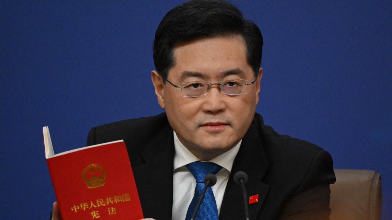 China's Foreign Minister Qin Gang holds a copy of China's constitution during a press conference at the Media Center of the National People's Congress (NPC) in Beijing on March 7, 2023. (Photo by NOEL CELIS / AFP)