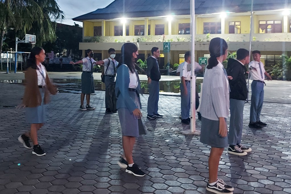 This picture taken on March 6, 2023 shows high school students gathering for the roll call on campus early in the morning in Kupang. - A pilot project in Kupang, the capital of East Nusa Tenggara province, has twelfth-graders at 10 high schools starting classes at 5:30 am. (Photo by ELIAZAR BALLO / AFP)