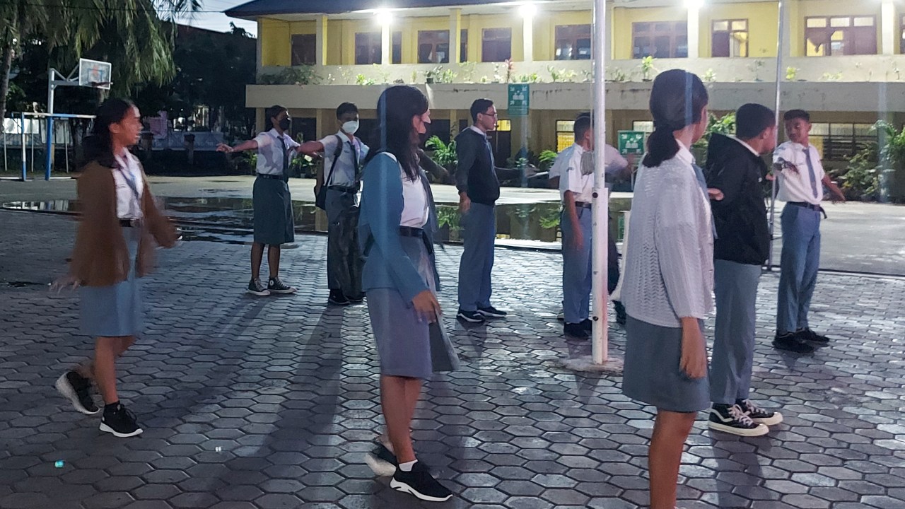 This picture taken on March 6, 2023 shows high school students gathering for the roll call on campus early in the morning in Kupang. - A pilot project in Kupang, the capital of East Nusa Tenggara province, has twelfth-graders at 10 high schools starting classes at 5:30 am. (Photo by ELIAZAR BALLO / AFP)