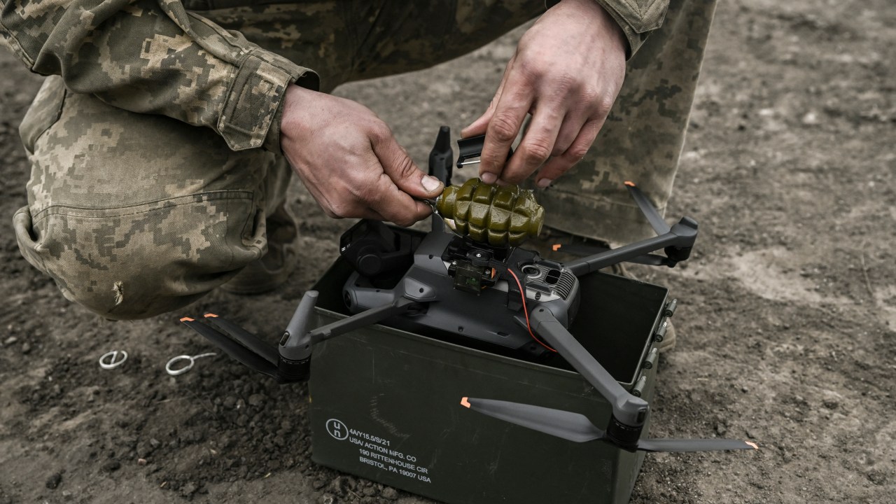 An Ukrainian serviceman attaches a hand grenade on a drone to use in an attack, near Bachmut, in the region of Donbas, on March 15, 2023. (Photo by Aris Messinis / AFP)