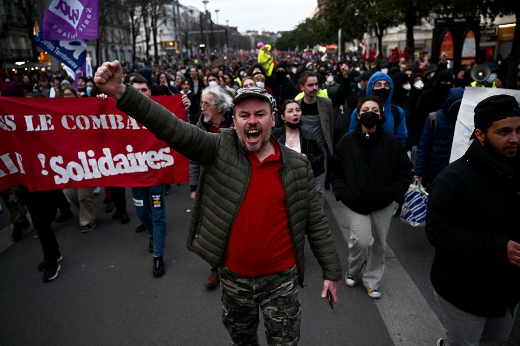 A protester gestures during a demonstration after the French government pushed a pensions reform through parliament without a vote, using the article 49.3 of the constitution, in Nantes, western France, on March 16, 2023. - The French president on March 16 rammed a controversial pension reform through parliament without a vote, deploying a rarely used constitutional power that risks inflaming protests. The move was an admission that his government lacked a majority in the National Assembly to pass the legislation to raise the retirement age from 62 to 64. (Photo by LOIC VENANCE / AFP)