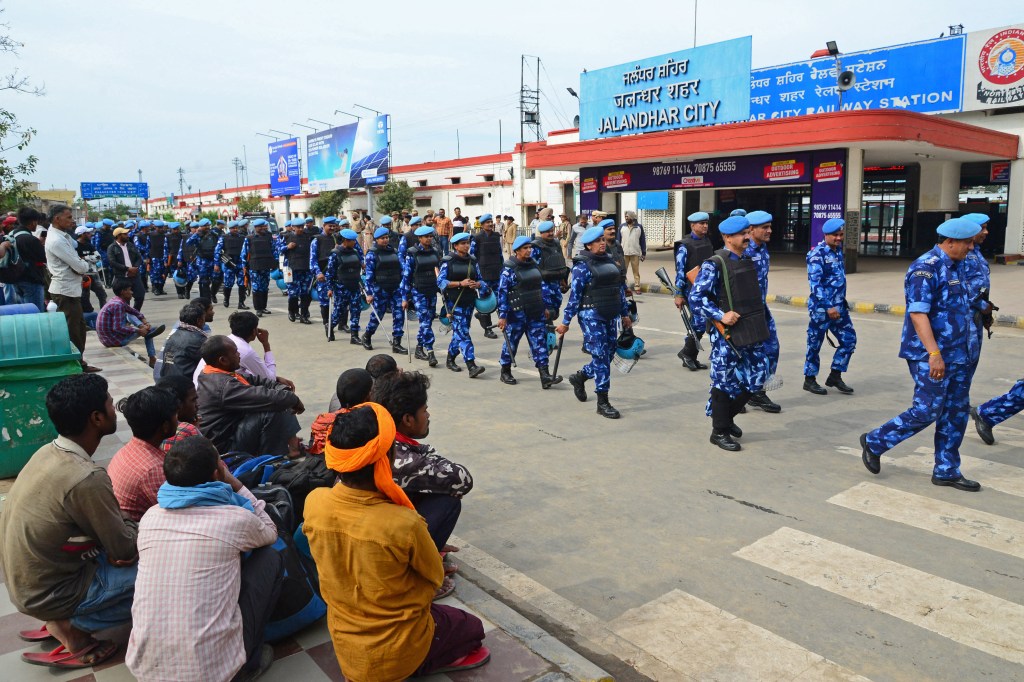 India's Rapid Action Force (RAF) personnel patrol in front of the railway station during a hunt for Sikh separatist, in Jalandhar on March 20, 2023. - Mobile internet in India's Punjab state remained suspended for a third day on March 20 as police hunted a radical Sikh preacher and protestors vandalised consulates abroad. (Photo by SHAMMI MEHRA / AFP)