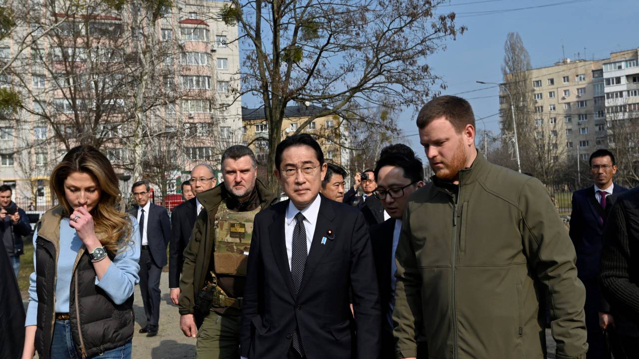 Japan's Prime Minister Fumio Kishida (C) visits the site of a mass grave found on the grounds of the church of Saint Andrew Pervozvannoho All Saints in the town of Bucha, during his visit to Ukraine on March 21, 2023, amid the Russian invasion of Ukraine. (Photo by Sergei CHUZAVKOV / AFP)