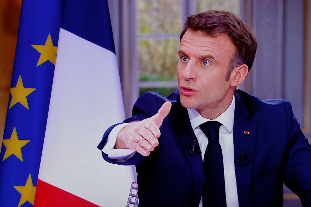 French President Emmanuel Macron is seen on screen as he speaks during a TV interview from the Elysee Palace, in Paris, on March 22, 2023. - French President is to make on March 22, 2023 his first public comments on the crisis sparked by his government forcing through a pensions overhaul, which has sparked violent protests and questions over his ability to bring about further change. (Photo by Ludovic MARIN / AFP)