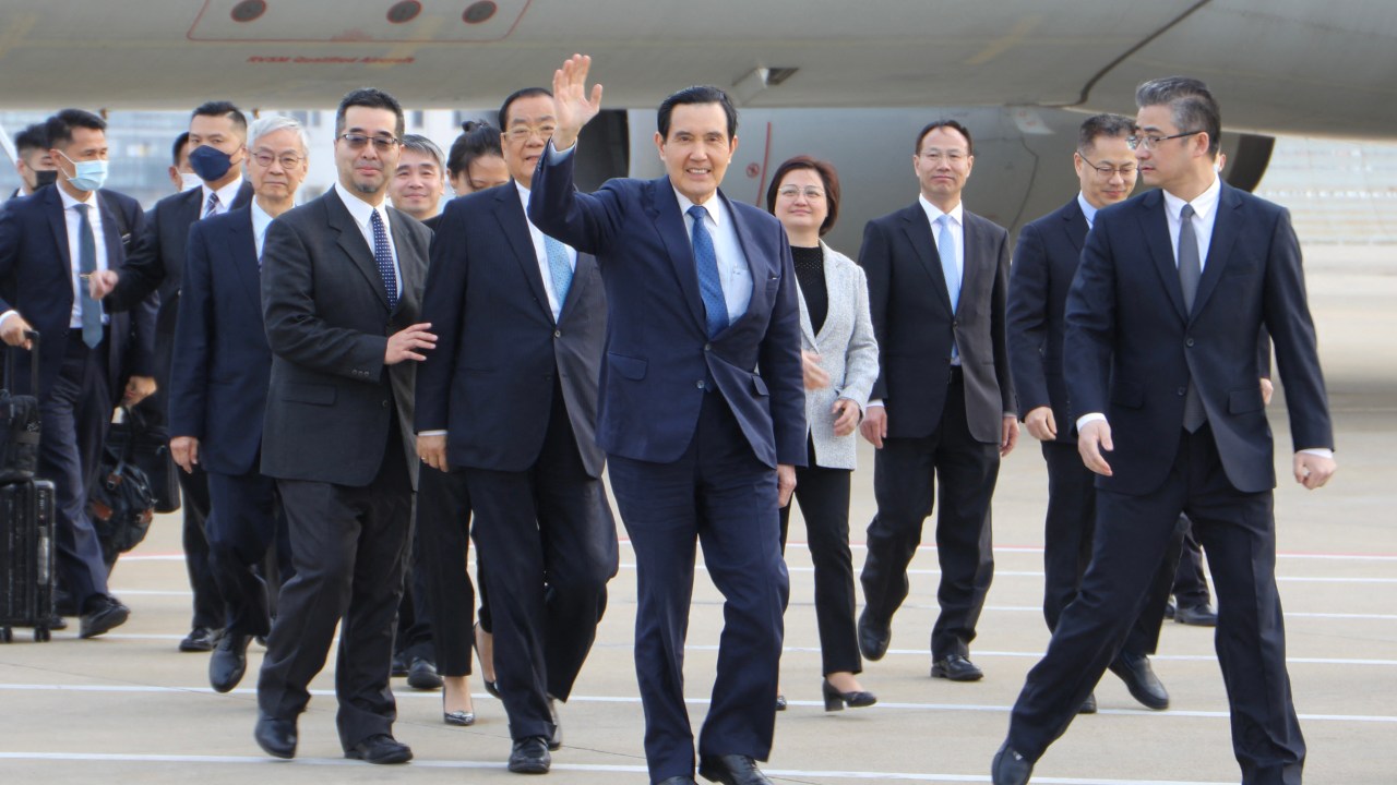 Ex-presidente taiwanês Ma Ying-jeou (C) acena ao chegar ao aeroporto de Xangai