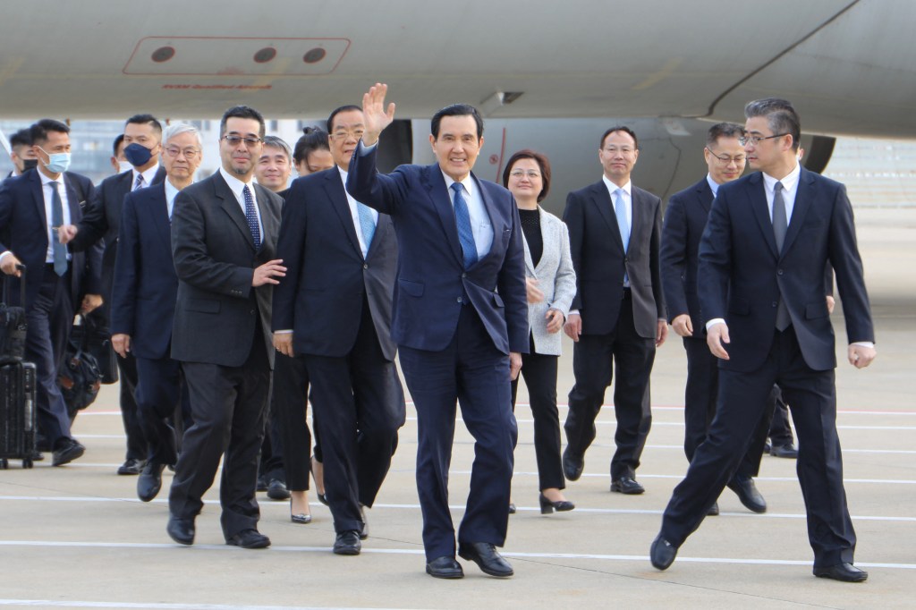 Ex-presidente taiwanês Ma Ying-jeou (C) acena ao chegar ao aeroporto de Xangai