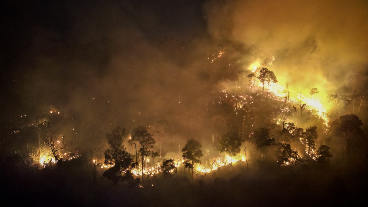 A forest fire burns on a mountain-side in Nakhon Nayok province, northeast of Bangkok on March 31, 2023. - Hundreds of Thai firefighters and soldiers battled a forest blaze less than 100 kilometres from Bangkok as the kingdom grapples with air pollution. (Photo by Jack TAYLOR / AFP)