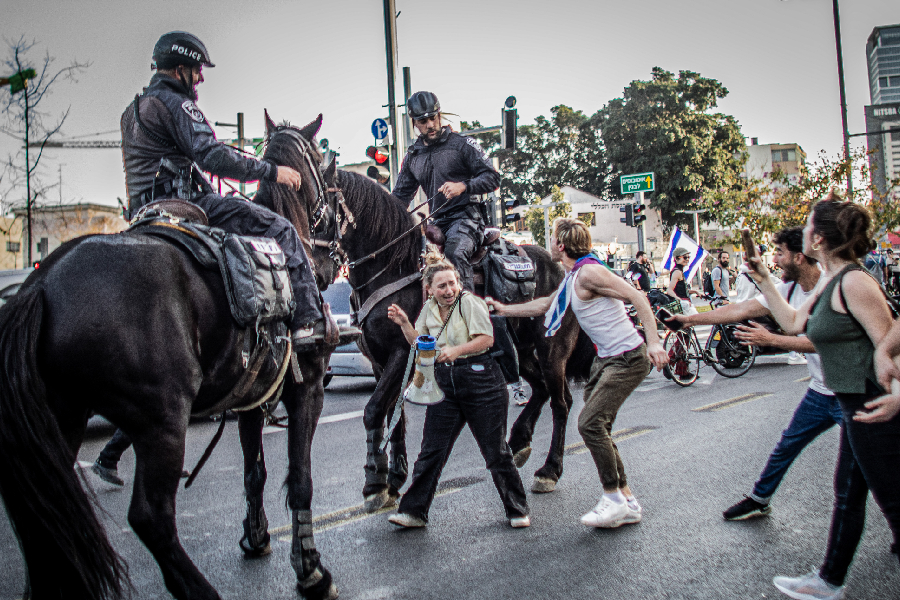 Policiais israelenses montados a cavalo empurram manifestantes durante protesto em Tel Aviv, Israel