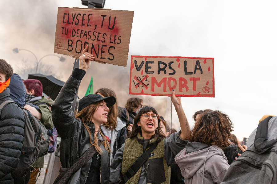 Protesters hold placards expressing their opinions during the demonstration. Thousands of people joined in protest in the Place de la Concorde, in Paris, after the announcement that the Macron government, through Prime Minister Elisaberth Borne, would trigger article 49.3 of the French Constitution that allows the government to force the approval of a bill without passing the National Assembly.