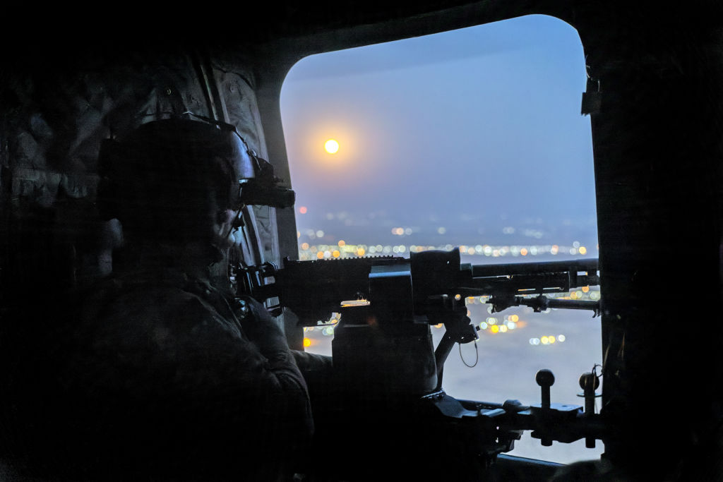 NORTHEASTERN SYRIA - MAY 26: A "supermoon" shines as a U.S. Army CH-47 Chinook helicopter gunner scans the desert while transporting troops on May 26, 2021 over northeastern Syria. U.S. forces, part of Task Force WARCLUB operate from remote combat outposts in northeastern Syria, coordinating with the Syrian Democratic Forces (SDF) in combatting residual ISIS extremists and deterring pro-Iranian militia. (Photo by John Moore/Getty Images)
