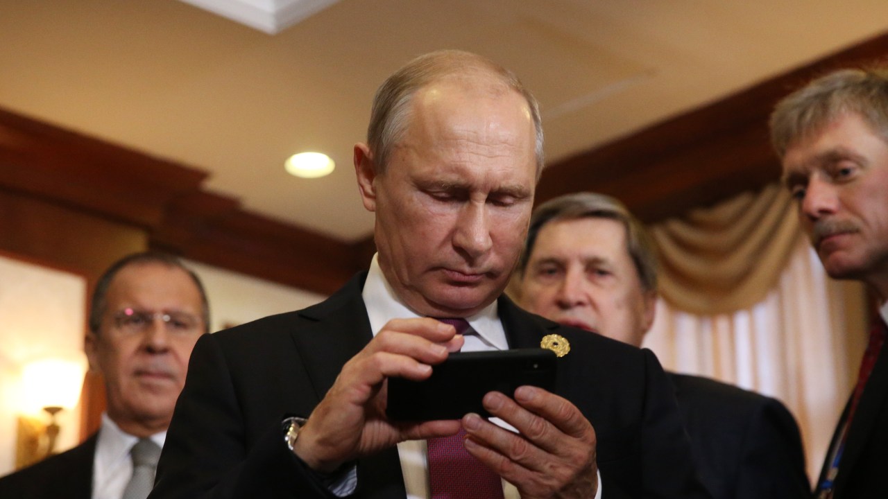 DA NANG, VIETNAM - NOVEMBER 10: (RUSSIA OUT) Russian President Vladimir Putin (C) holds an iPhone as his spokesman Dmitry Peskov (R) looks on prioir to a bilateral meeting with Philippines President Rodrigo Duterte (not pictured) at the APEC Leaders Summit on November 10,2017 in Da Nang, Vietnam. Russian President Vladimir Putin has arrived to Vietnam to attends the APEC Leaders Summit. (Photo by Mikhail Svetlov/Getty Images)