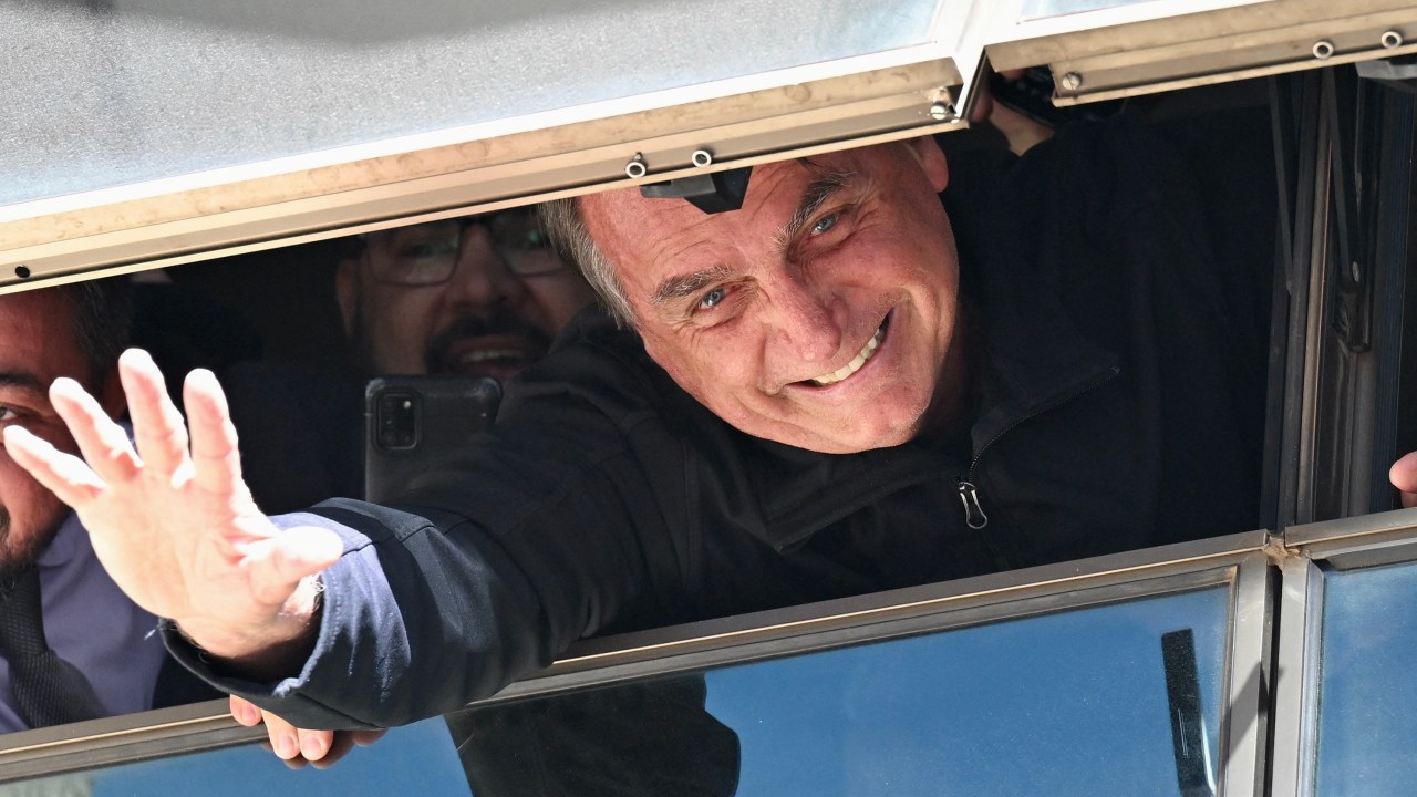 Former Brazilian president Jair Bolsonaro greets supporters from a window at the Liberal Party headquarters of n Brasilia on March 30, 2023. - Disconsolate over his "unjust" defeat in Brazil's divisive 2022 elections, Bolsonaro was uncharacteristically quiet when he slipped out of Brazil in the twilight of his presidential term for a self-imposed exile in Florida. (Photo by EVARISTO SA / AFP)