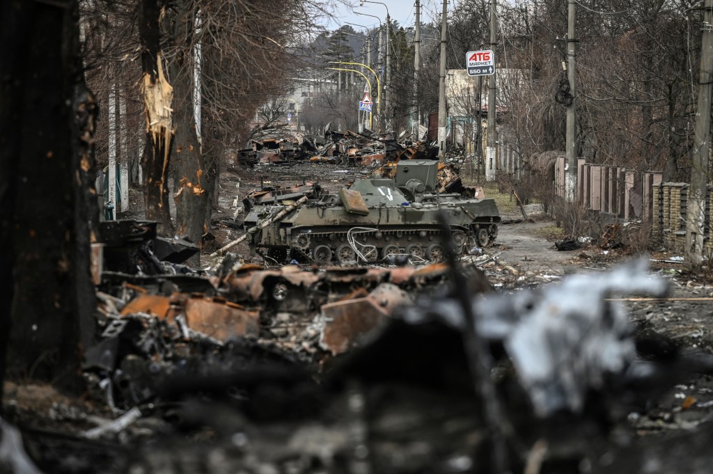 (FILES) In this file photo taken on March 4, 2022 Destroyed Russian armored vehicles line the street in the city of Bucha, west of Kyiv. - Russian forces pulled back from the commuter town northwest of the capital on March 31, 2022, just over one month after President Vladimir Putin ordered his troops to invade Ukraine. A year after its liberation by Ukrainian forces, Bucha and its people are still confronted by the atrocities blamed on Russian forces during their occupation of the city. President Volodymyr Zelensky said Friday that Ukraine would "never forgive" Moscow for its occupation of Bucha, one year after Russia withdrew from the town near Kyiv leaving corpses strewn throughout deserted streets. (Photo by ARIS MESSINIS / AFP)