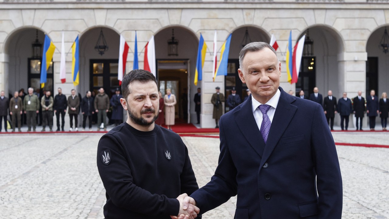 Ukraine's President Volodymyr Zelensky (L) and Polish President Andrzej Duda shake hands during a welcoming ceremony in front of the presidential palace in Warsaw, Poland, on April 5, 2023. - During the visit, Zelensky will meet his Polish counterpart, Andrzej Duda and is due to deliver remarks in the historic centre of the Polish capital. (Photo by Wojtek Radwanski / AFP)