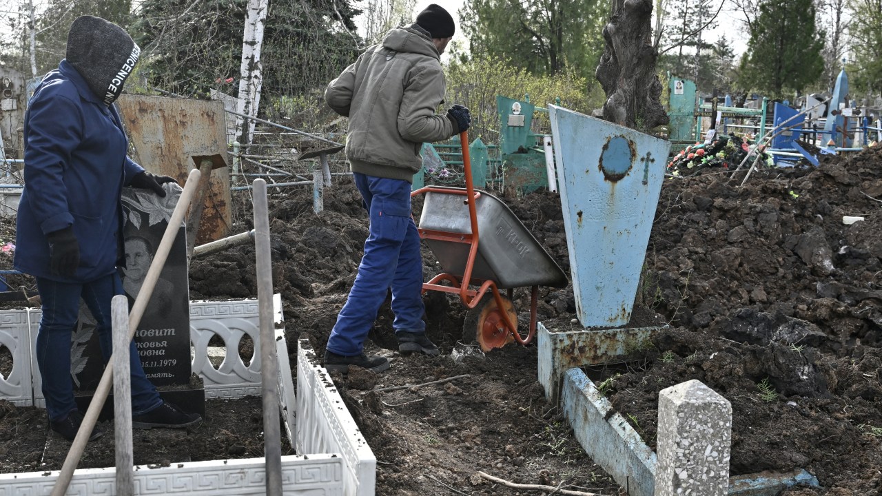 Municipal workers clean up a graveyard after a shelling of the central cemetery in the town of Kramatorsk, in the region of Donbass, on April 11, 2023, amid the Russian invasion of Ukraine. (Photo by Genya SAVILOV / AFP)