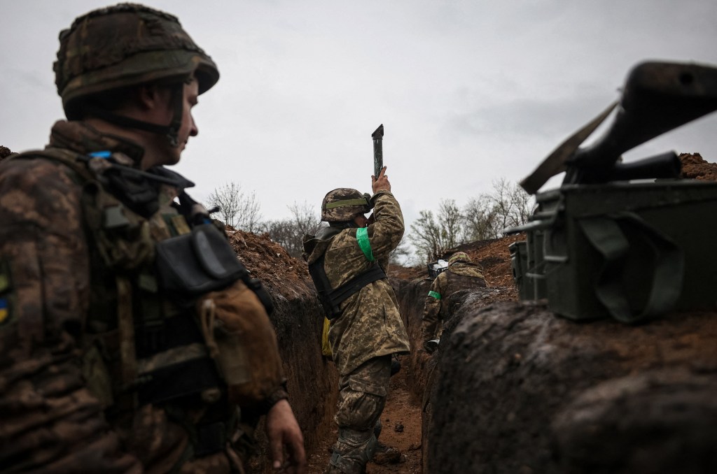 A Ukrainian infantryman of the 57th Separate Motorized Infantry Brigade "Otaman Kost Khordienko" uses a periscop to observe an enemy positions from a trench at an undisclosed location near the town of Bakhmut, Donetsk region, eastern Ukraine on April 13, 2023, amid the Russian invasion of Ukraine. (Photo by ANATOLII STEPANOV / AFP)