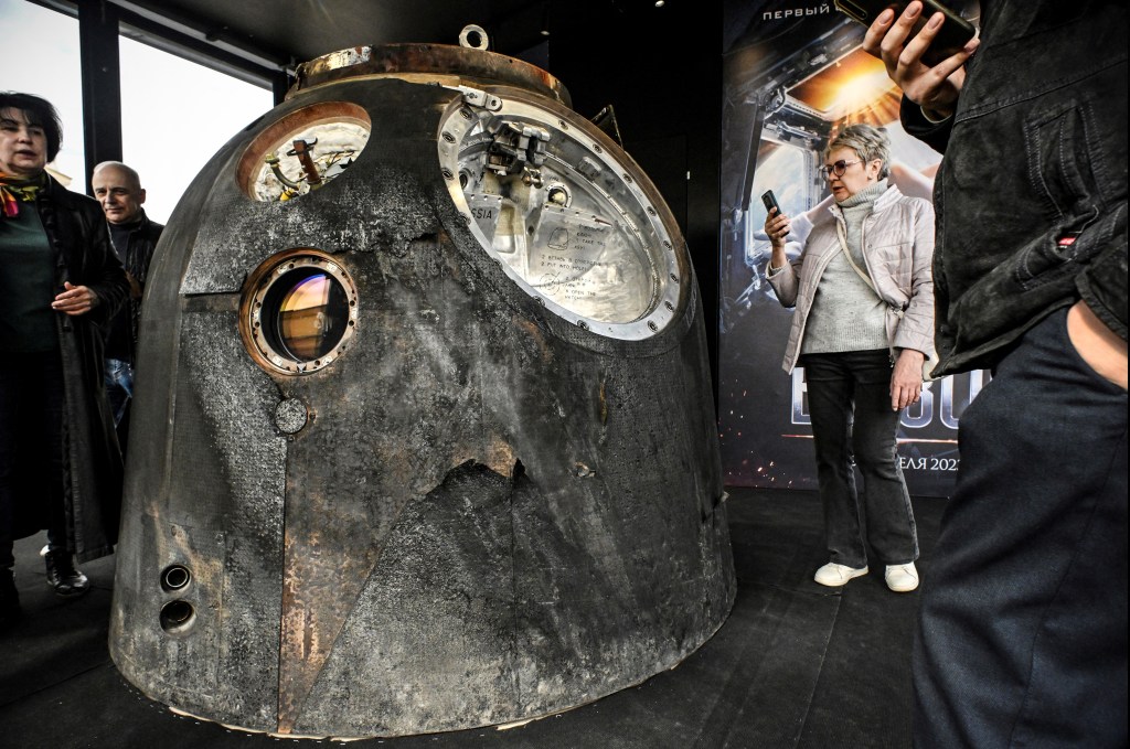 Visitors inspect the Russian Soyuz MS-18 space capsule which brought back to the Earth on October 17, 2021 Russian actress Yulia Peresild, in Moscow on April 18, 2023. - The Russian actress and film director spent 12 days on the International Space Station (ISS) shooting scenes for the first movie made in Space. The first night of "Challenge" is scheduled on April 20, 2023. (Photo by Alexander NEMENOV / AFP)