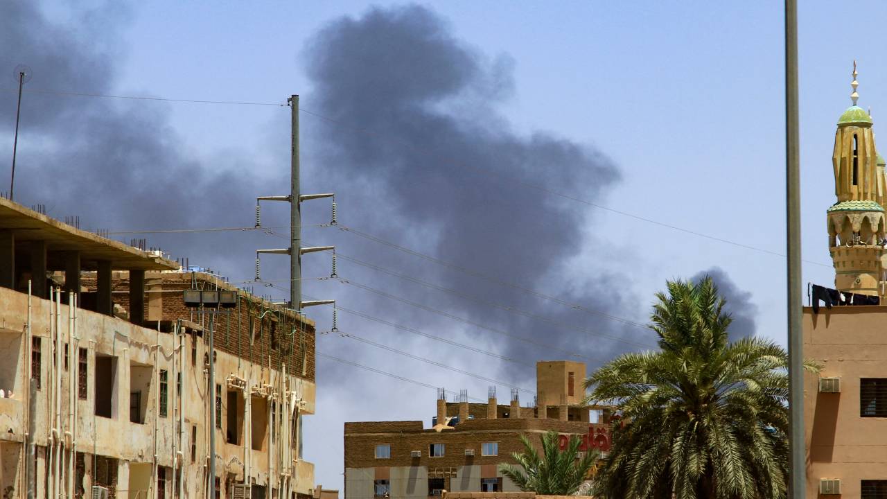 Smoke rises behind buildings in Khartoum on April 19, 2023, as fighting between the army and paramilitaries raged for a fifth day after a 24-hour truce collapsed. - The violence erupted on April 15 between the forces of two generals who seized power in a 2021 coup: army chief Abdel Fattah al-Burhan and his deputy, Mohamed Hamdan Daglo, who commands the paramilitary Rapid Support Forces (RSF). (Photo by AFP)