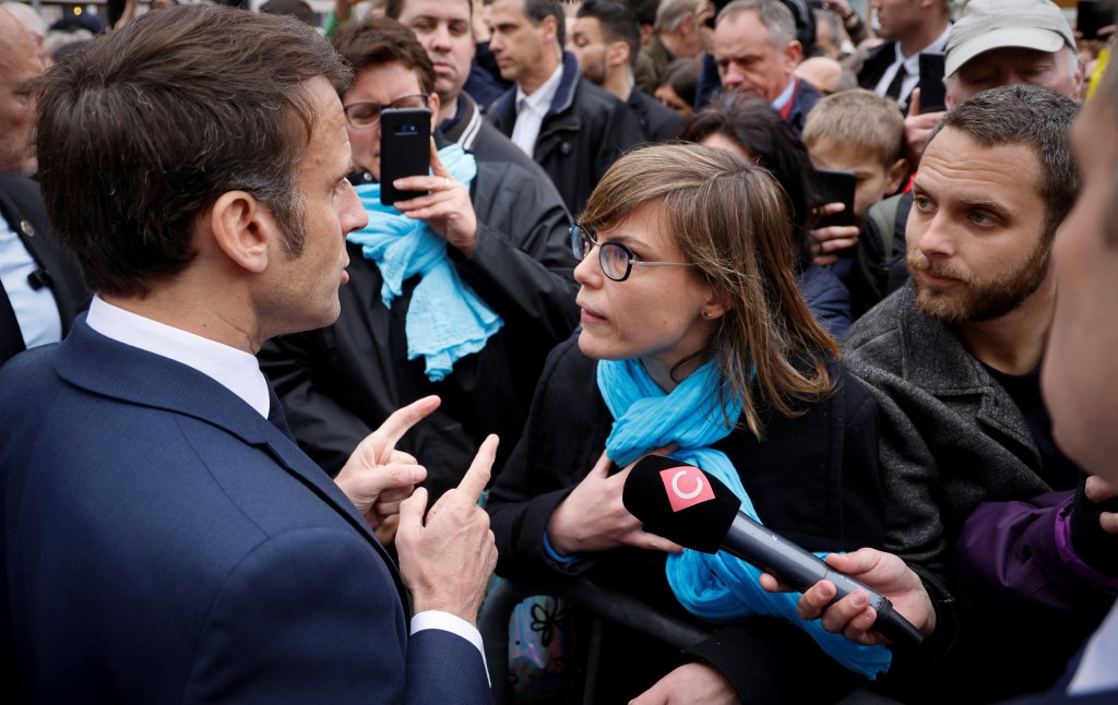 French President Emmanuel Macron (L) talks to French National Union of Autonomous Trade Unions' (Union nationale des Syndicats Autonomes - Unsa) general secretary for the Grand Est region Chloe Bourguignon (R) opposed to the pension reform, in Selestat, eastern France on April 19, 2023. - Macron, whose reforms including an increase to the pension age have earned him widespread animosity in recent weeks, makes a visit on the theme of reindustrialisation. (Photo by Ludovic MARIN / POOL / AFP)