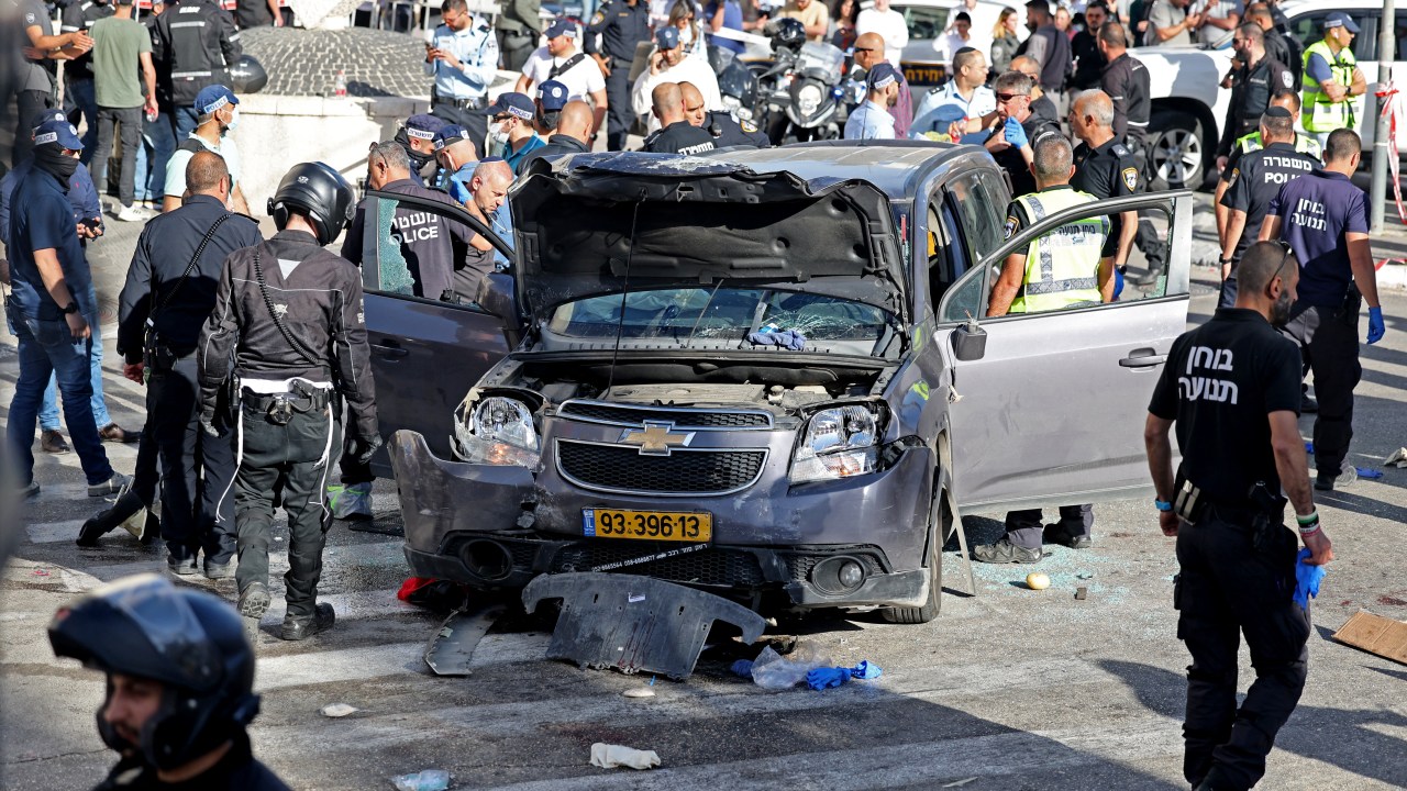 Israeli police and emergency personnel inspect a damaged vehicle following an incident in Jerusalem's Mahane Yehuda market on April 24, 2023. (Photo by AHMAD GHARABLI / AFP)