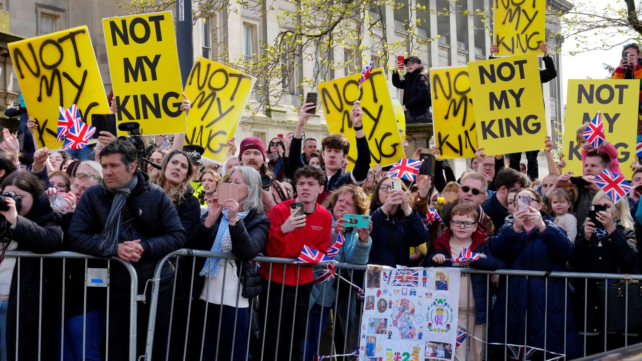 Protesters hold signs reading "Not My King" ahead of the arrival of Britain's King Charles III and Britain's Queen Consort Camilla for a visit to the Liverpool Central Library on April 26, 2023 to officially mark the Library's twinning with Ukraine's first public Library, the Regional Scientific Library in Odessa. (Photo by Jon Super / POOL / AFP)