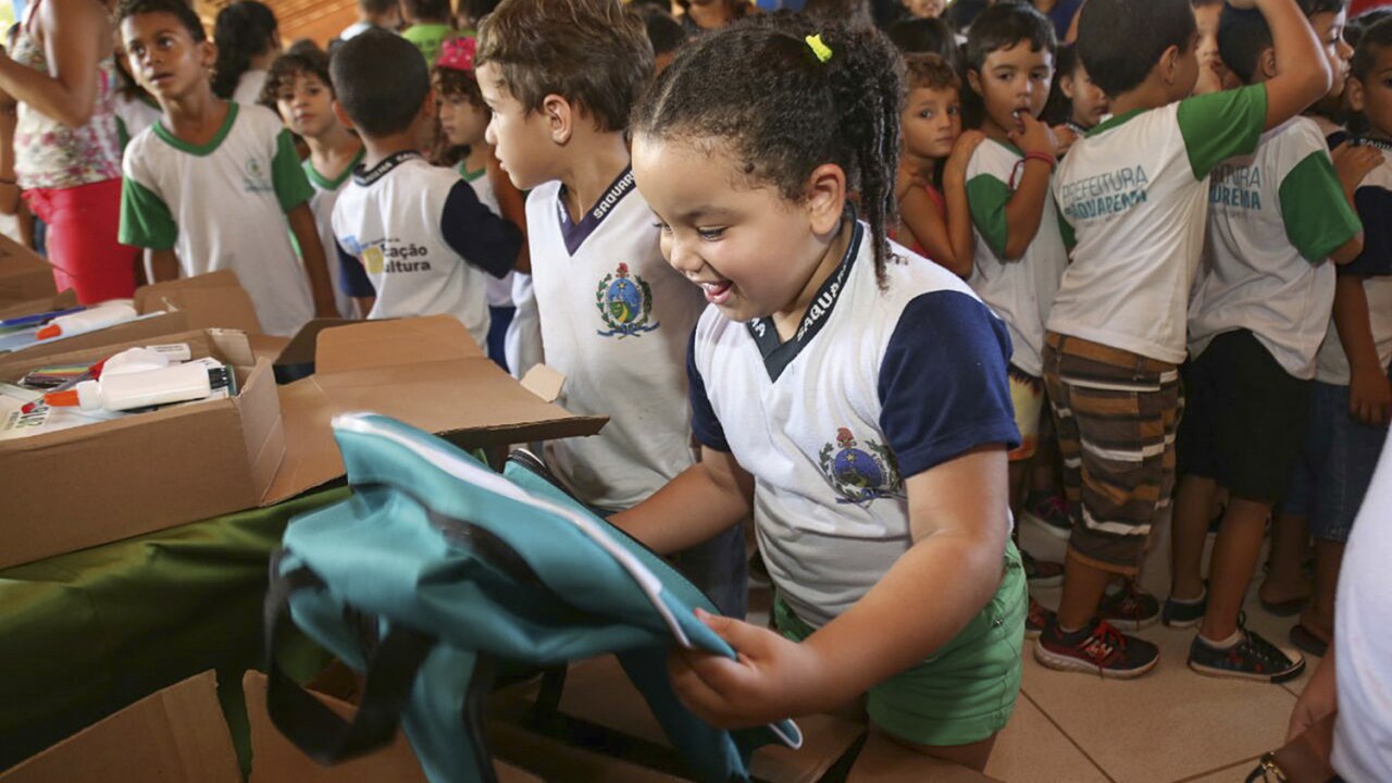 RINDO À TOA - Crianças em escola local: rede oferece material, uniforme, notebook, transporte e bônus a professor