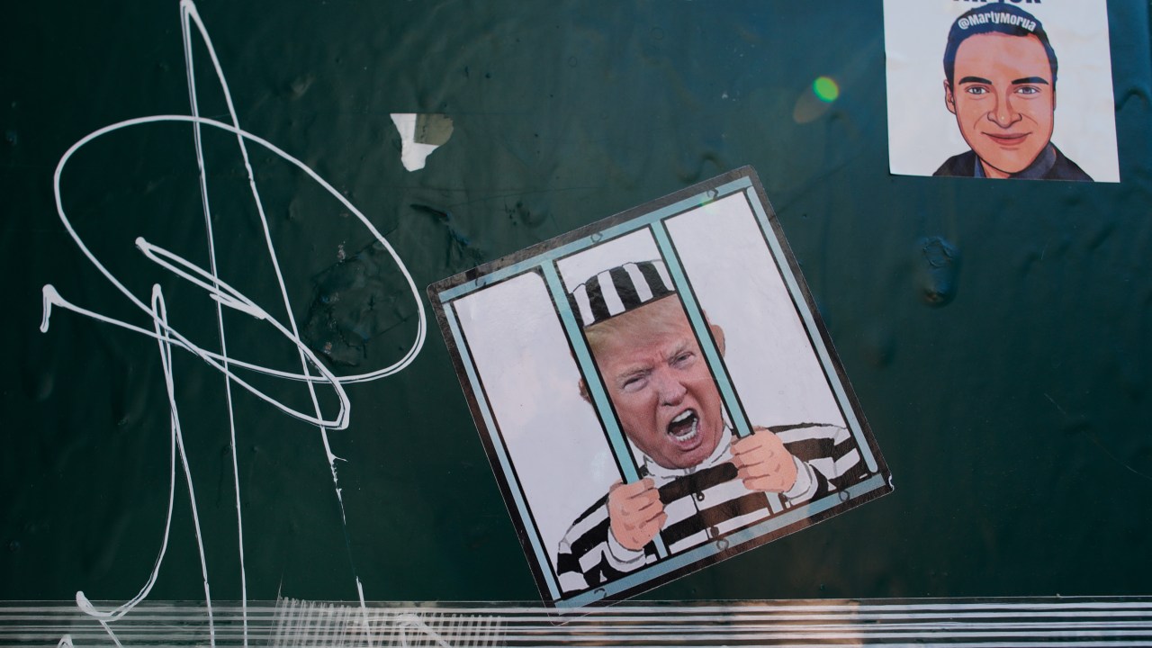 A poster with the face of former U.S. President Donald Trump is placed outside of the Manhattan Criminal Courthouse on April 03, 2023 in New York City