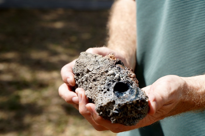 Fulgurito, que resultou do impacto de um raio sobre uma árvore na Flórida, na mão de um cientista -