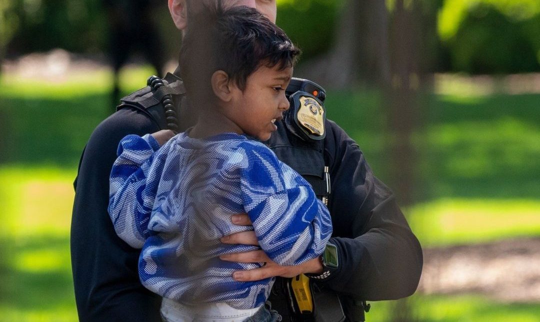 Policiais do Serviço Secreto dos Estados Unidos carregam uma criança que passou pela cerca da Casa Branca na Avenida Pensilvânia em Washington, DC.