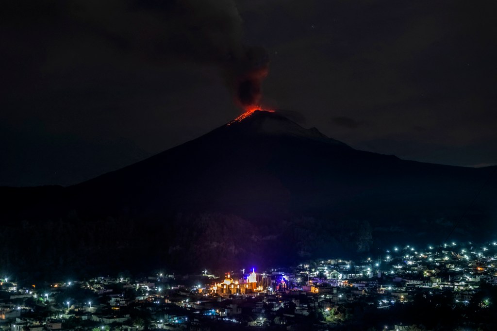 The Popocatepetl Volcano spews ash and smoke as seen from thr Santiago Xalitzintla community, state of Puebla, Mexico, on May 22, 2023. Mexican authorities on May 21 raised the warning level for the Popocatepetl volcano to one step below red alert, as smoke, ash and molten rock spewed into the sky posing risks to aviation and far-flung communities below. Sunday's increased alert level -- to "yellow phase three" -- comes a day after two Mexico City airports temporarily halted operations due to falling ash. (Photo by ERIK GOMEZ TOCHIMANI / AFP)