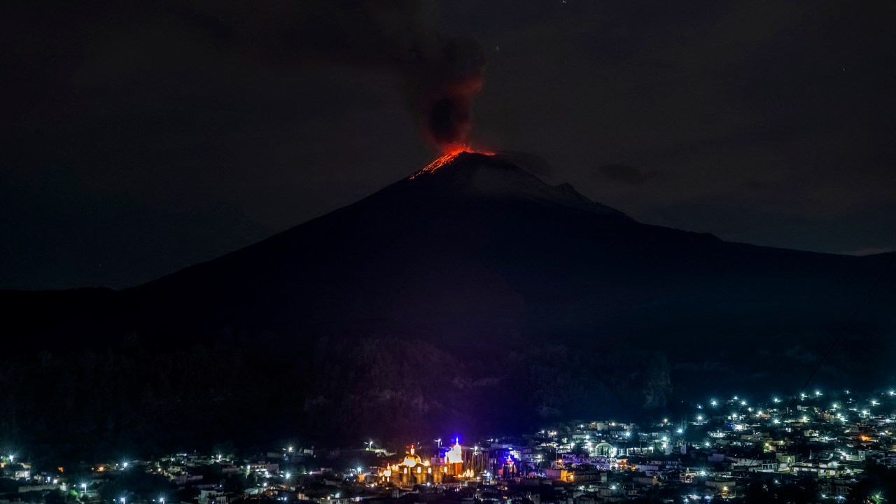 The Popocatepetl Volcano spews ash and smoke as seen from thr Santiago Xalitzintla community, state of Puebla, Mexico, on May 22, 2023. Mexican authorities on May 21 raised the warning level for the Popocatepetl volcano to one step below red alert, as smoke, ash and molten rock spewed into the sky posing risks to aviation and far-flung communities below. Sunday's increased alert level -- to "yellow phase three" -- comes a day after two Mexico City airports temporarily halted operations due to falling ash. (Photo by ERIK GOMEZ TOCHIMANI / AFP)