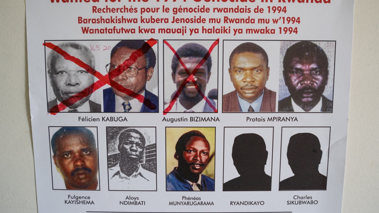 (FILES) A picture taken on May 19, 2020, shows the face of Protais Mpiranya, one of the key suspects in the 1994 Rwandan genocide, and Fulgence Kayishema (bottom L), one of the last four fugitives sought for their role in the 1994 Rwanda genocide, on a wanted poster on the wall at the Genocide Fugitive Tracking Unit office in Kigali, Rwanda. Fulgence Kayishema, one of the last four fugitives sought for their role in the 1994 Rwanda genocide, has been arrested in South Africa, UN investigators said on May 25, 2023. (Photo by Simon Wohlfahrt / AFP)